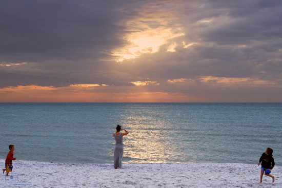 Boys Tossing Football and Woman Taking Picture, Naples, Florida