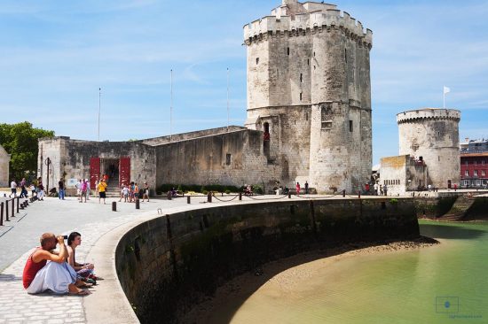 Tourists with Saint Nicolas and Chain Towers, La Rochelle, France Tourists with Saint Nicolas and Chain Towers, La Rochelle, France