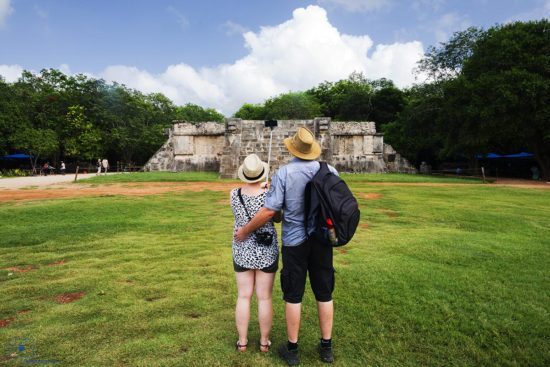 Couple Taking a Picture Using a Selfie Stick in Front of the Venus Platform, Chichen Itza, Mexico
