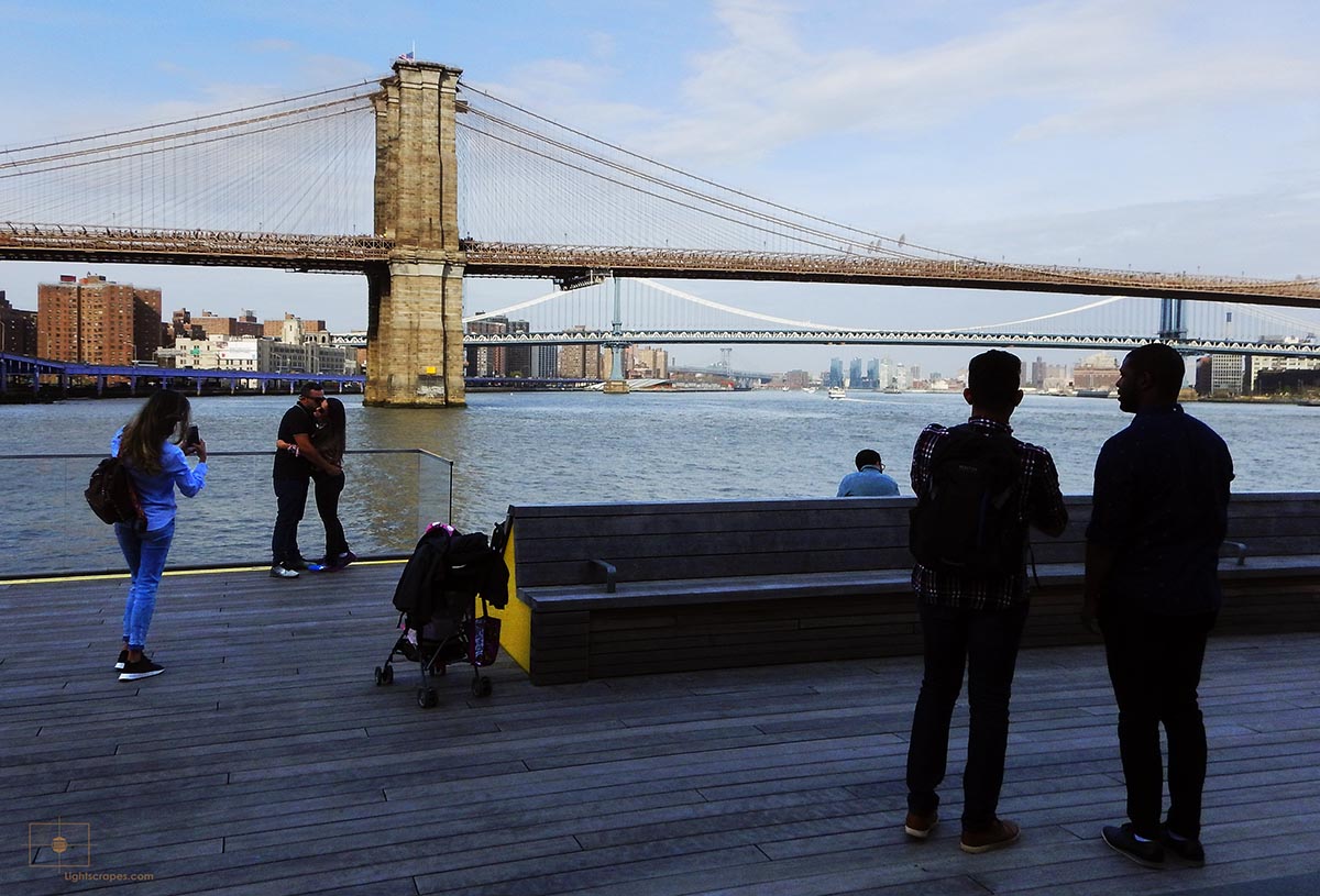 Couple Kissing while Others Look over the East River - South Street Seaport, New York City
