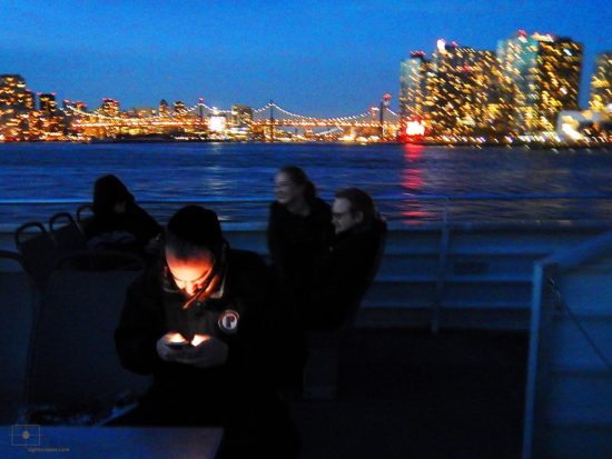 East River Ferry, New York City – Man Texting Religious Man Texting at Night on the East River Ferry - East River, New York City