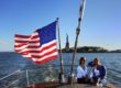 Women Sitting against the Taffrail with the Statue of Liberty and Flags - New York Harbor, New York